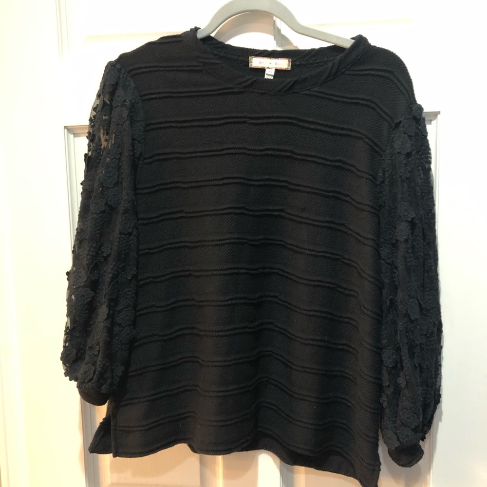 Black top with embellished sleeves. Anthropologie
